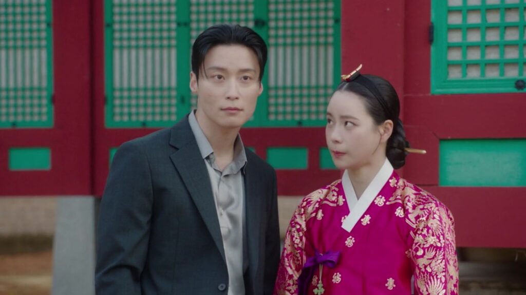 Who Is Heo Nam-jun? Meet Cha Se-gye From ‘My Royal Nemesis’ A Korean man in a suit (Heo Nam-jun as Cha Se-gye) and a Korean woman in traditional clothing (Lim Ji-yeon as Shin Seo-ri) stand in front of a traditional palace in 'My Royal Nemesis'.