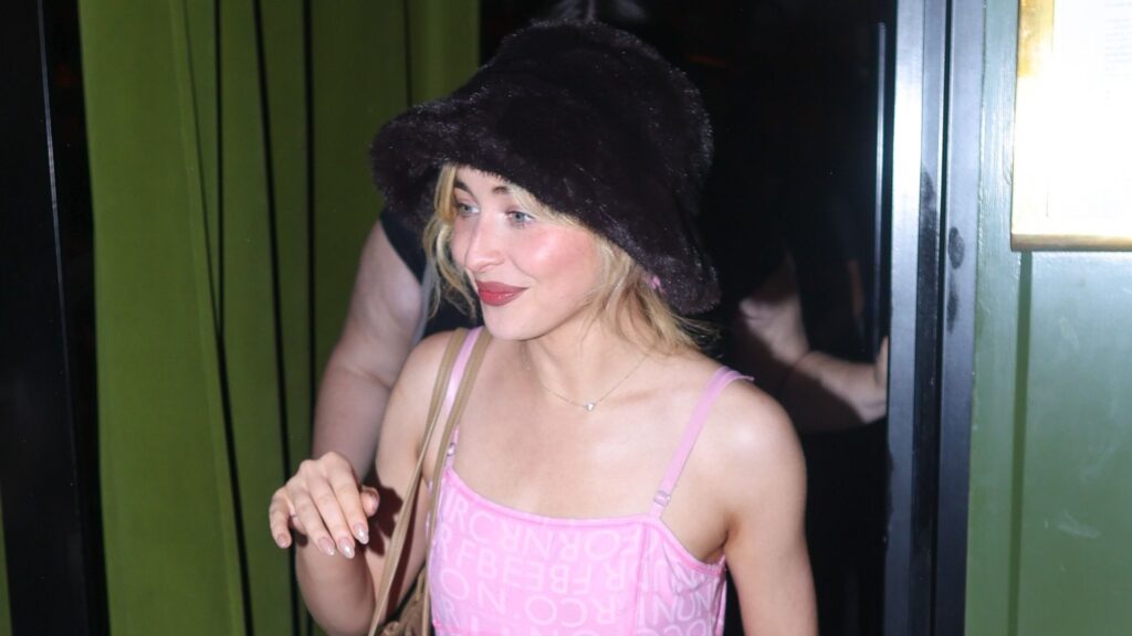 Sabrina Carpenter braves the Paris heatwave in a fluffy bucket hat, a slinky pink dress, and carrying a vintage Hermes bag