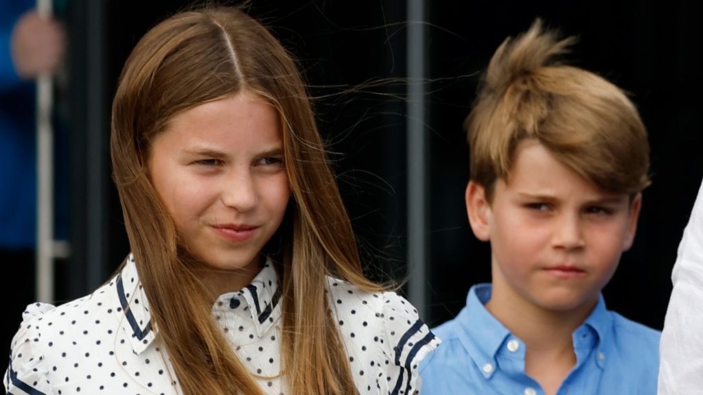What Will Happen to Charlotte and Louis When George Is King? Princess Charlotte has long dark blonde hair and wears a white and black polka dot dress while Princess Louis wears a blue shirt